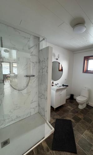 a bathroom with a glass shower and a toilet at Guesthouse Myrkholt II in Tungufell