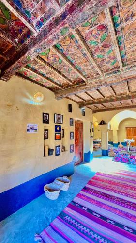 a room with colorful carpets on the walls and ceilings at Kasbah Restaurant Citoyenne in Agoudal