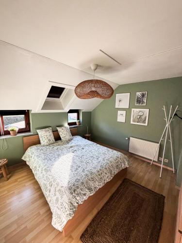 ein Schlafzimmer mit einem Bett und einer grünen Wand in der Unterkunft La Cardamine in Marche-en-Famenne