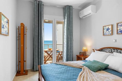 a bedroom with a bed with a view of the ocean at Haraki Aqua Marine in Haraki