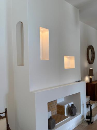 a living room with a white fireplace with two lights at Horizon Beach House by Andros Villas Collection in Andros