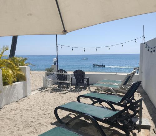 dos sillas y sillas en una playa con el océano en Bed & Breakfast T.T, en Río Hato