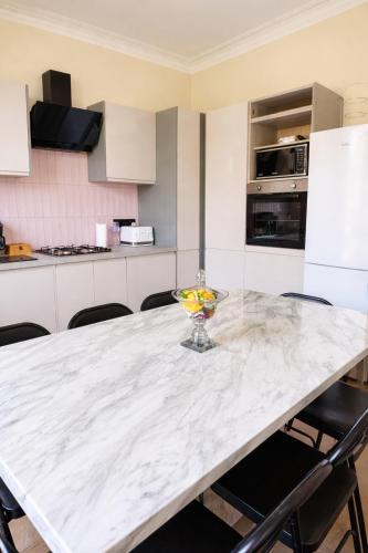 a kitchen with a table with a bowl of fruit on it at Luxury Victorian 5 bedroom apartment by Lady road apartments in Edinburgh