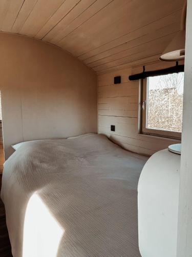 a bed in a small room with a window at BelleLiv in Nijlen