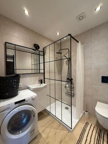 a washing machine in a bathroom with a washer at Studio Lec in Giżycko