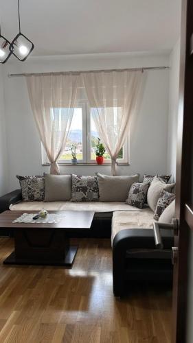 a living room with a couch and a large window at Rest apartment Niksic in Nikšić