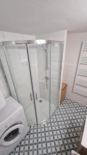 a bathroom with a shower and a washing machine at Chalupa Kruh in Doksy