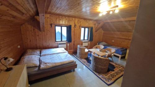 a bedroom with a bed and chairs in a wooden cabin at Chalupa Kruh in Doksy