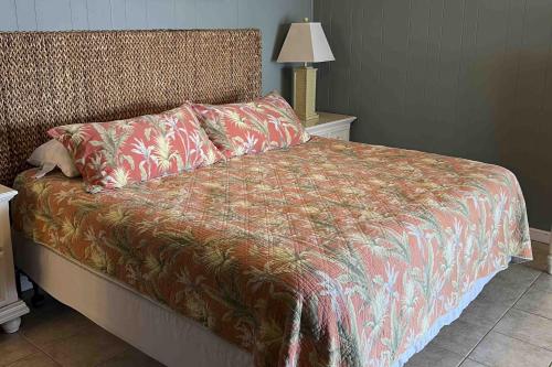 a bedroom with a bed with a red comforter at Salty Paws II in Kill Devil Hills