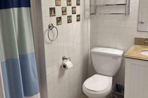 a bathroom with a toilet and a shower curtain at Salty Paws II in Kill Devil Hills