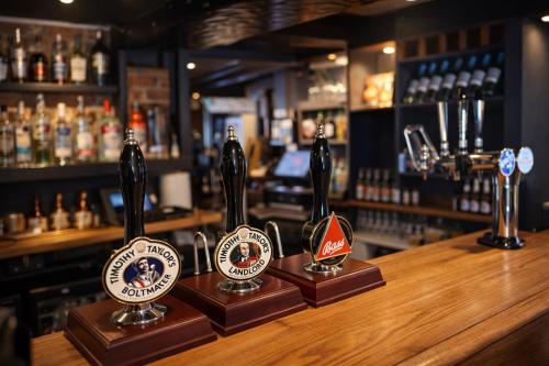 a bar with three bottles of beer on a counter at The Three Horseshoes Boutique Rooms in Dunstall