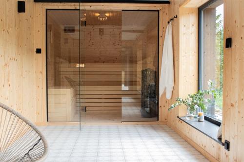 a glass door to a sauna in a wooden house at Ostoya Skalanka KDN in Zwardoń
