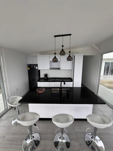 a kitchen with two stools and a black counter top at casa campestre la daniela in Filandia