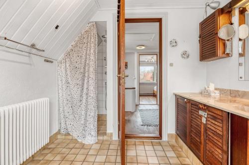a kitchen with a door leading into a bathroom at Cozy House Close to Beach and B&O in Struer