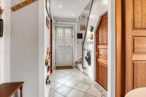 a hallway with a white door and a tile floor at Cozy House Close to Beach and B&O in Struer