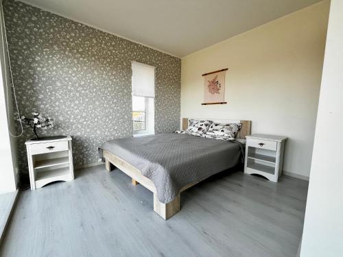 a bedroom with a bed and two night stands at Vahtralehe majutus in Tartu