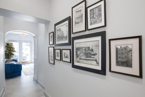 a group of framed pictures on a wall at The King Street House By Kasa in Alexandria