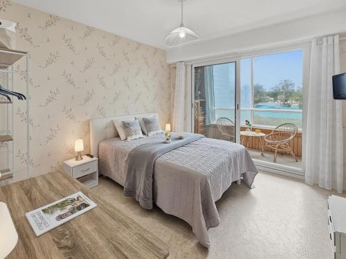 a bedroom with a bed and a view of the ocean at Sérénité vue mer in Courseulles-sur-Mer