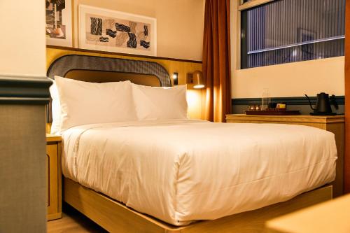 a bedroom with a white bed with a window at Union Hotel in Toronto