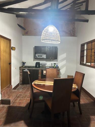 a table and chairs in a kitchen with a chandelier at Casa casco urbano in San Gil