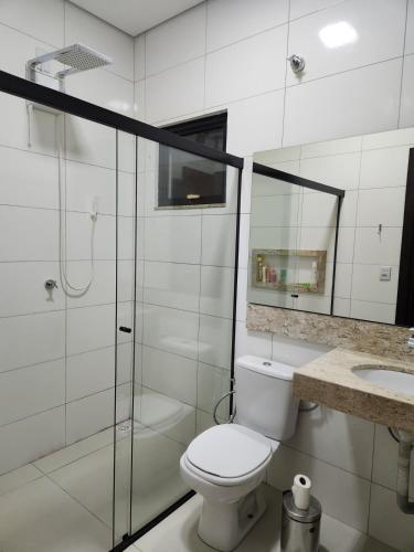 a bathroom with a toilet and a shower and a sink at Casa Completa e Funcional in Sinop