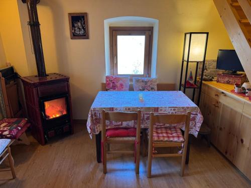 a dining room with a table and a fireplace at La Casetta di Cri Morbegno in Morbegno