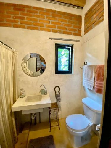 a bathroom with a toilet and a sink and a mirror at Casitas Eclecticas in Sayulita