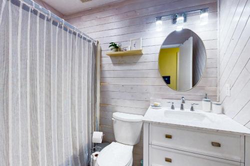 a bathroom with a toilet and a sink and a mirror at Salty Tails in Kill Devil Hills