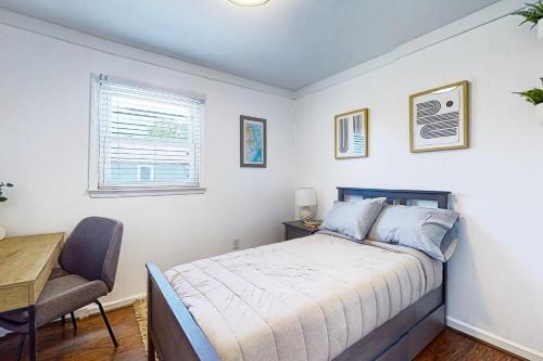 a bedroom with a bed and a desk and a chair at Salty Tails in Kill Devil Hills