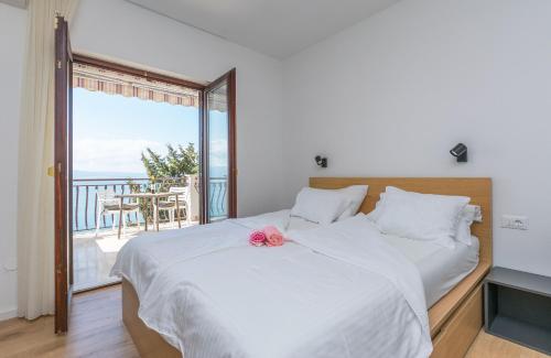 a bedroom with a bed with a view of the ocean at Apartments Blue Adriatic View in Jesenice