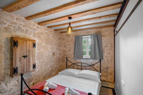 a bedroom with a bed in a stone wall at Apartment Heritage Stonehouse in Ugljan