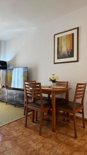 a dining room with a table and chairs and a tv at CityLife Torrevieja in Torrevieja