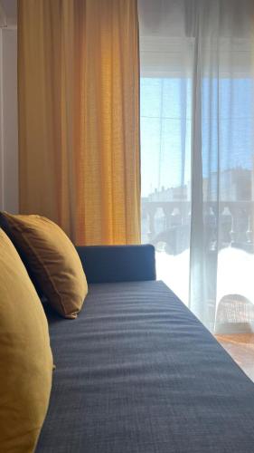 a bedroom with a bed with yellow pillows and a window at CityLife Torrevieja in Torrevieja