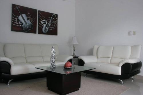 a living room with two couches and a coffee table at Residencial Vista Del Bosque in Santiago de los Caballeros