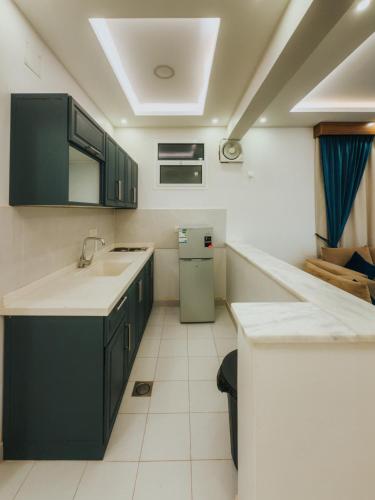 a kitchen with green cabinets and a refrigerator at شقق أونيسن للشقق المخدومة Onsen Serviced Apartments in Buraydah