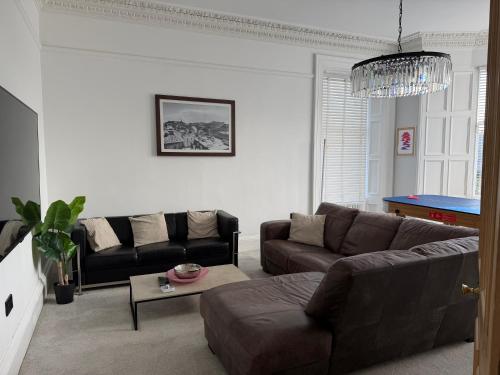 a living room with a couch and a table at Luxury Victorian 5 bedroom apartment by Lady road apartments in Edinburgh