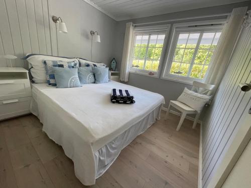 a bedroom with a large white bed with blue pillows at Spacious villa with heated pool and stunning view in Tokenes