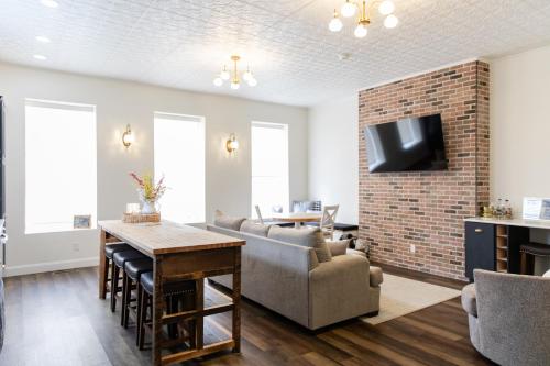 a living room with a couch and a tv on a brick wall at Historic Market Plaza Overlook in Wheeling