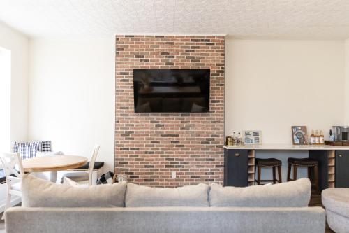 a living room with a couch and a brick fireplace at Historic Market Plaza Overlook in Wheeling
