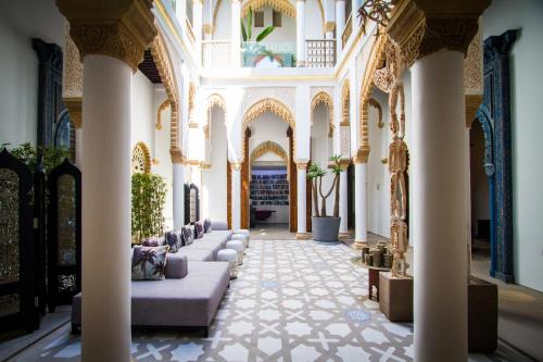 a lobby with columns and couches in a building at Euphoriad in Rabat