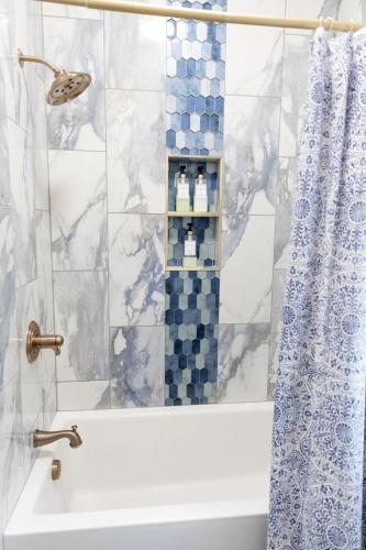 a bathroom with a shower with a tub and a sink at Historic Market Plaza Overlook in Wheeling