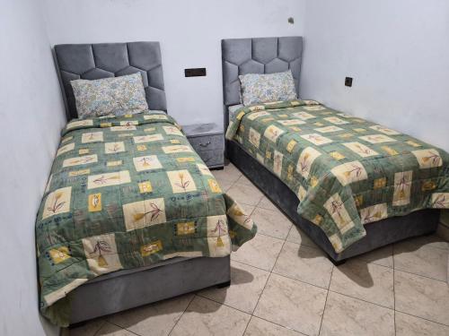 two beds sitting next to each other in a room at Appartement villa spacieuse 200m2 terrasse prive grand jardin et piscine in Meknès