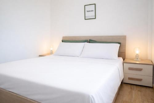 a white bed with white pillows in a bedroom at La Casa al mare Torre San Giovanni in Torre San Giovanni Ugento