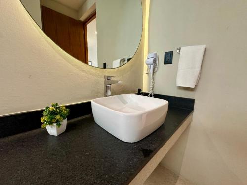 a bathroom with a large white sink and a mirror at Mangle 13 Modern Apartments-Rooftop pool, close to Ferry in Cancún