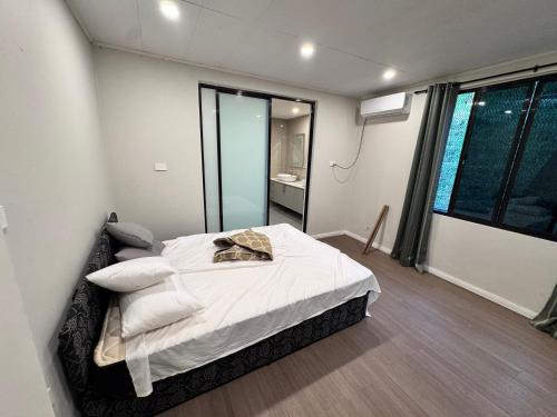 a bedroom with a bed with white sheets and pillows at Reddy Homes in Lautoka