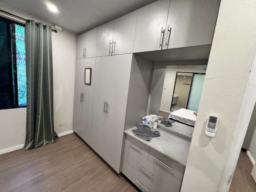 a bathroom with white cabinets and a sink and a mirror at Reddy Homes in Lautoka