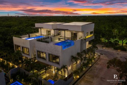 an aerial view of a house with a sunset at Piedras Luxe by Prestigia - Villa in Tulum