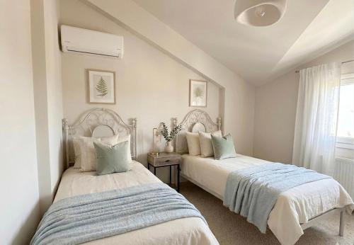 two beds in a white room with a window at Valeria's Apartment in Argostoli
