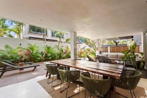 a dining room with a wooden table and chairs at Twin Luxury Villas - Groups Prstigia MX in Tulum