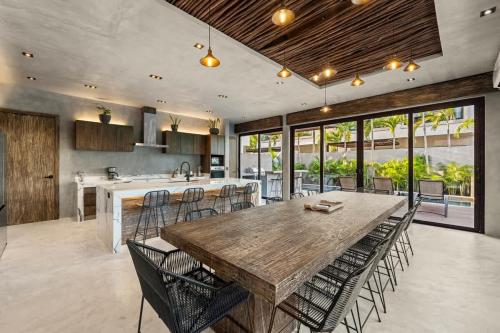 a kitchen with a large wooden table and chairs at Twin Luxury Villas - Groups Prstigia MX in Tulum